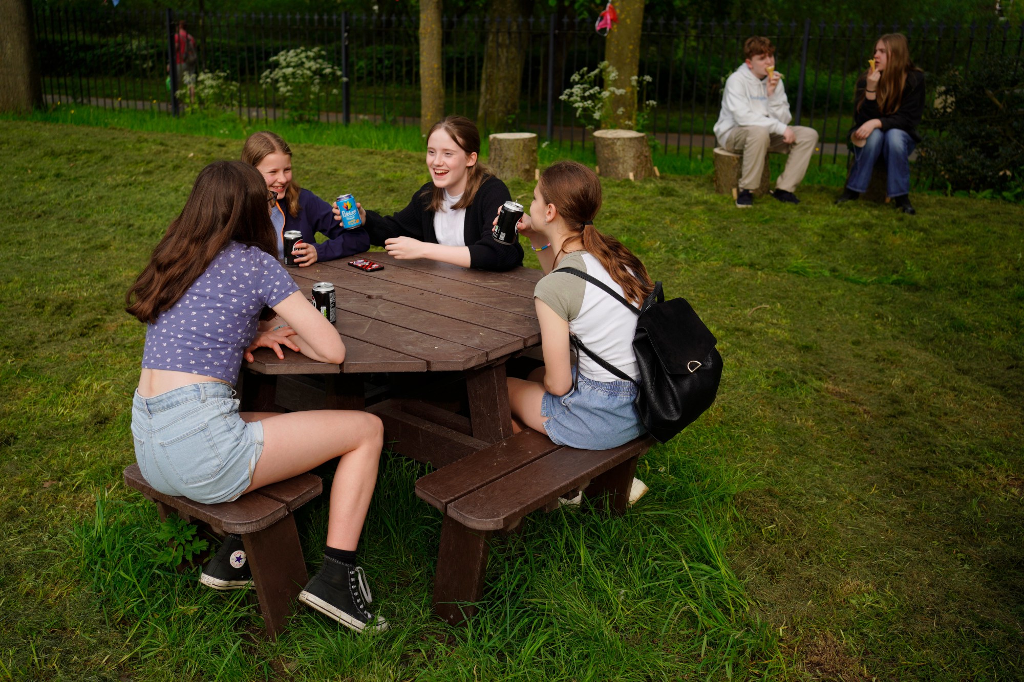 Teenage girls chatting on picnic bench in Rowntree Park in York